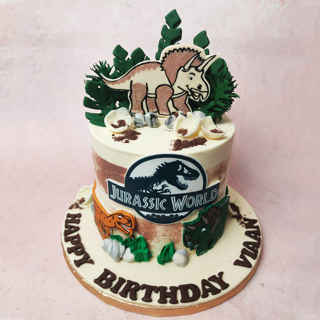Edible wonders, including white chocolate and cookie crumb eggs, magically recreate the hatching of dino eggs and set the stage for a Jurassic World Cake adventure.