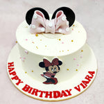 The highlight of this Disney Minnie Cake is the oversized pink fondant bow with white polka dots, nestled between glossy black Minnie ears—an iconic silhouette that needs no introduction. Lightly scattered around the soft vanilla base are golden and blush sugar pearls, adding just the right amount of sparkle.
