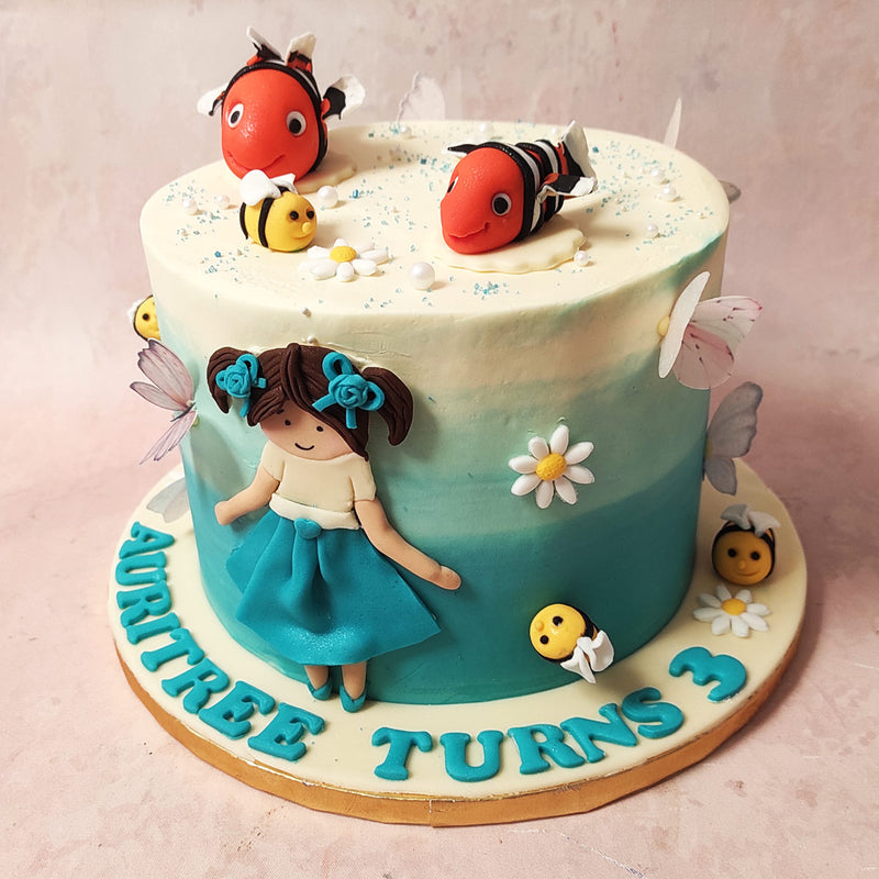 Adorning this design are white flowers but the true showstopper of this Disney theme cake is the edible figurine of a little girl who bears a striking resemblance to Darla, the enthusiastic niece of P. Sherman from “Finding Nemo.” 