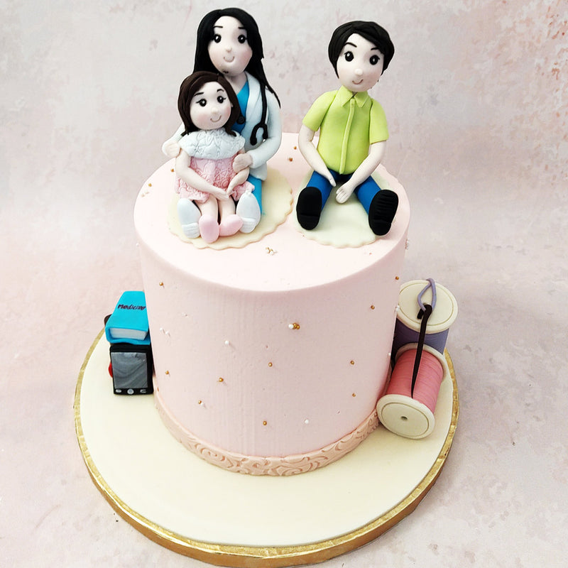 Featuring a light pink base, a father, daughter and doctor mom sitting on top and spools of thread at the side, this parents cake recreates all the elements of home and hearth. 