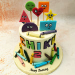 Surrounding this Shapes Cake are charming edible crayons, adding a touch of creativity and fun, reminiscent of a child's first experiences with drawing and colouring.