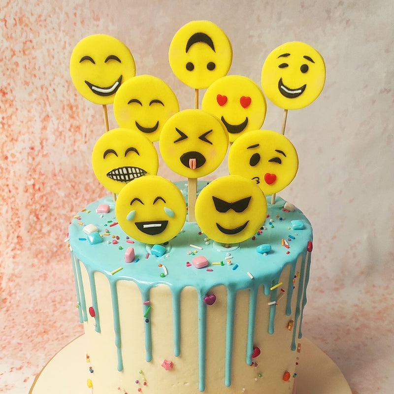 Atop this Smiley Cake, a delightful array of fondant emoji faces, each showcasing a different expression, creates a playful and engaging display. 