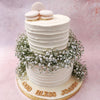 Featuring a simplistic, artistic and minimalistic aesthetic, this two tier communion cake comes in decadent, textured, white buttercream with macarons on top that resemble communion bread. 