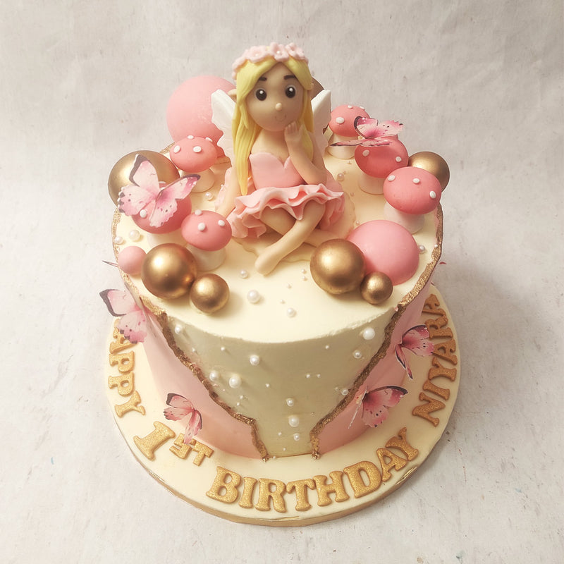 The centerpiece of this Fairy and butterfly birthday Cake for kids is the stunning gold vertical fault line that runs through the middle of the design. 