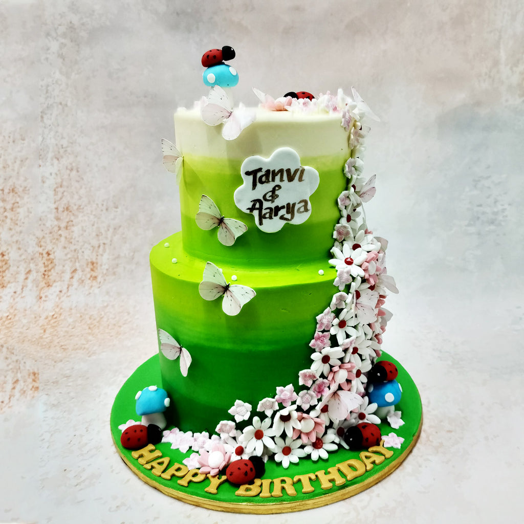 This two-tier flower garden cake beckons with its dark green to white ombre expanse.