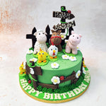 Atop the vibrant green Farmyard Cake, which mimics a lush meadow, stands an adorable array of farm animals, each meticulously crafted with a playful touch. 