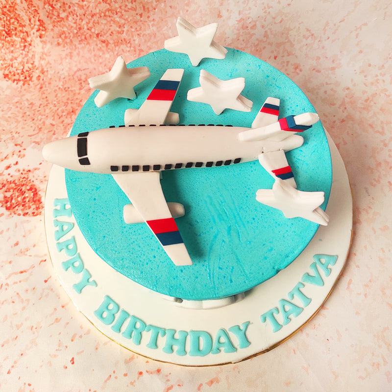 The first glance captures the sleek white aeroplane perched gracefully atop a vibrant blue Flight Cake, a delightful depiction of flight and adventure. 