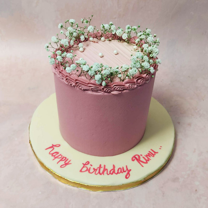 This simple pink cake with flowers features a minimalistic design that  is a testament to its sophistication. 