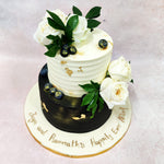 The top tier features a creamy white buttercream with horizontal texture lines, delicately adorned with flecks of gold leaf that catch the light and add a touch of luxury to this Flower Garden Cake. 
