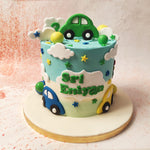 The top tier of this Flying Car Cake features a vibrant green car, perched atop fluffy white clouds, as if it’s driving through a magical sky. 