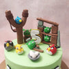 Picture this: the determined angry birds poised for fight or flight, ready to take on the challenge of the mischievous green pigs scattered across this Angry BirdsTheme Cake. 