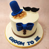 The blue bow delicately placed on top of this groom to be cake adds a pop of colour, reminiscent of a dapper bowtie, further accentuating the gentlemanly theme.