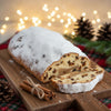 Authentic German Marzipan Stollen Bread sliced, showing rich fruit and the almond marzipan center, dusted with powdered sugar.
