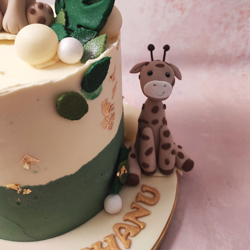 Atop this captivating giraffe theme cake sit two edible figurines, bringing the jungle to life: A majestic lion and a  graceful giraffe.