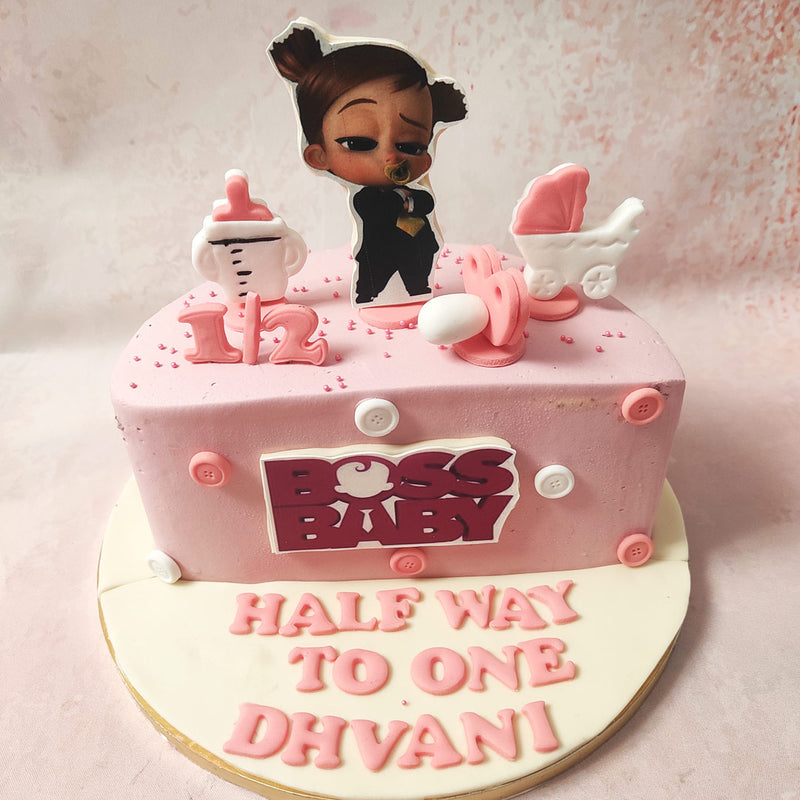 A stroller, milk bottle, and pram adorn this boss baby girl cake design, representing the journey of growth and discovery that every little boss baby experiences. 