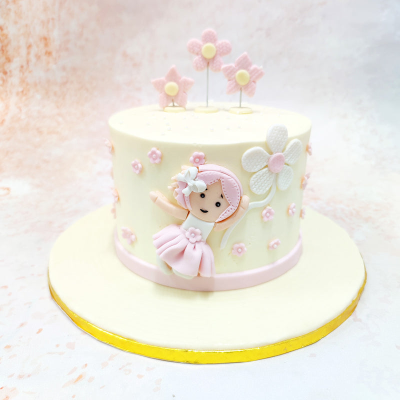 The pastel pink and white base of this Girly Flower Birthday Cake For Girls features a figurine of a little girl in a pink dress. 