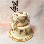 Rustic and oxidised, edible gold flowers bloom across the expanse of both tiers, adding a touch of antiquated charm to this Elegant Butterfly Cake. 