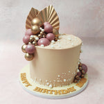 Our Bohemian Cake features a canvas of peach-coloured delight, adorned with delicate white pearls and opulent spheres of purple and gold, gracefully cascading down. 