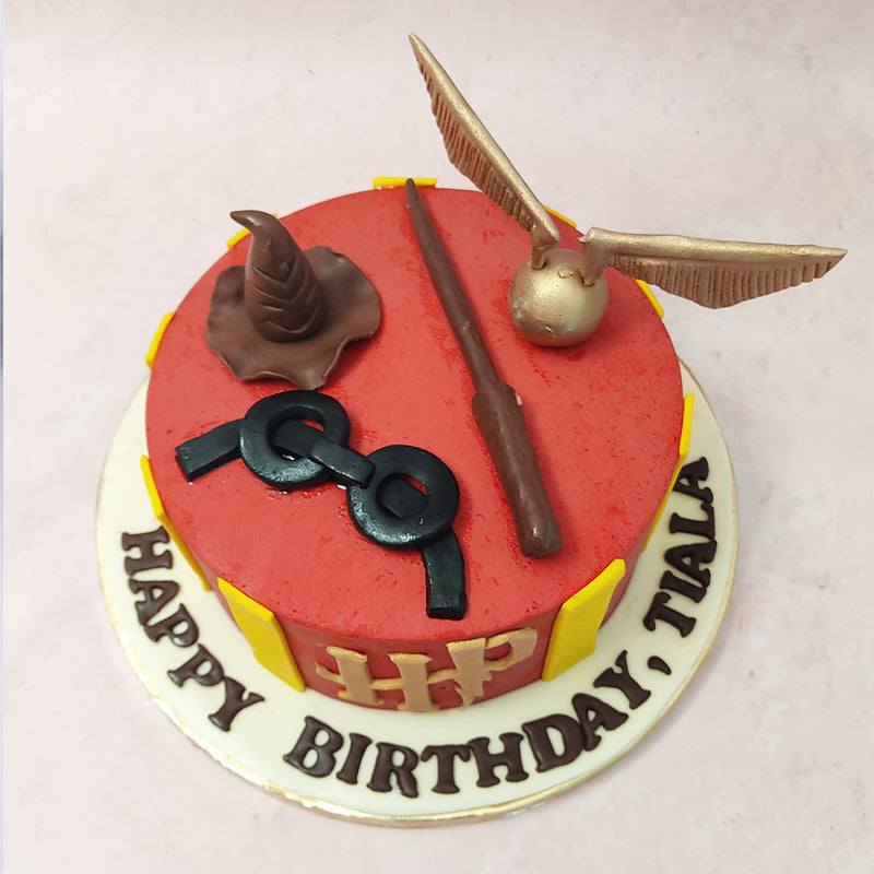 This red and gold Harry Potter cake is a true delight for all Potterheads, featuring a base in a vibrant shade of red adorned with yellow stripes reminiscent of the iconic Gryffindor colours. 
