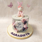 With its grey base, this first haircut cake is adorned with edible flowers and butterflies. 