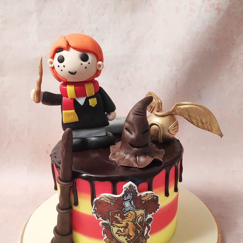 Also on this Harry Potter theme cake is a chocolate wand, an edible figurine of Ron Weasley himself, a chocolate rendition of the Sorting Hat, edible book of spells and the infamous Golden Snitch. 