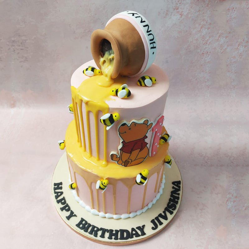 Bumblebees flit and flutter across this Honey Pot Cake, adding a whimsical touch that's as sweet as Pooh's favourite treat. 