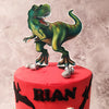 The top tier of our Jurassic Dinosaur cake is enveloped in vibrant red fondant with silhouettes of dinosaurs and a lively green figurine of a T-Rex proudly stands on top