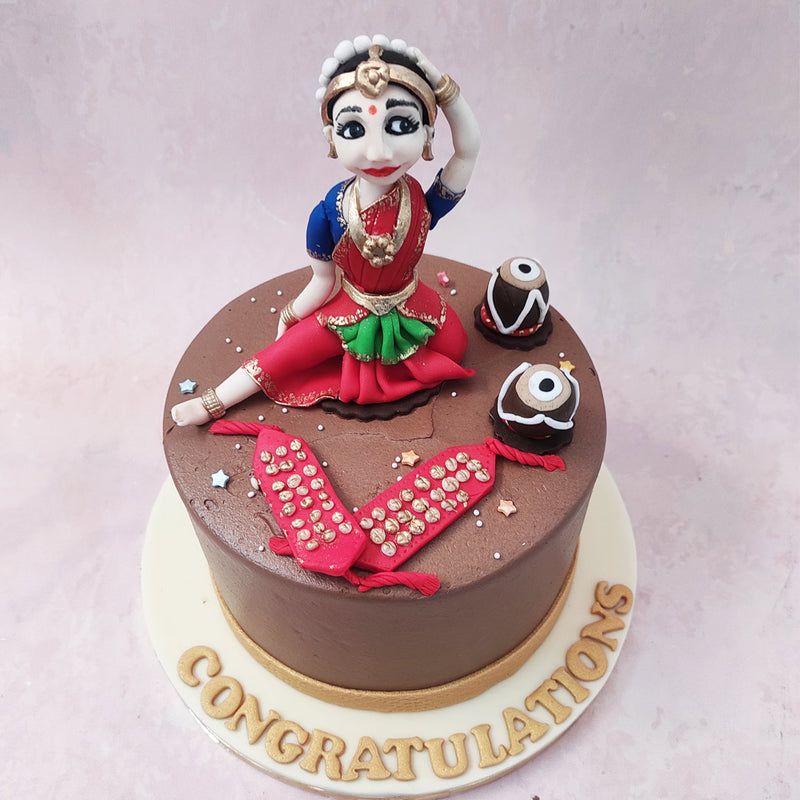 Adorned with a delicate gold ribbon around the bottom that symbolises grace, this Kathak dance theme cake embodies the grandeur of dance itself. 
