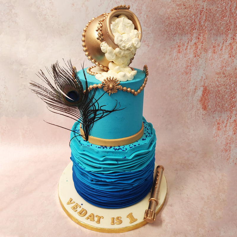 The bottom tier of this Lord Krishna birthday cake features a textured blue ombre design, symbolising his divine nature.  