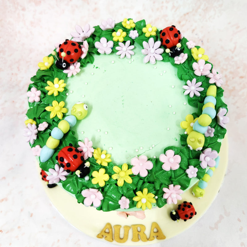 Scattered around the top of this Ladybug Cake are adorable ladybirds and a playful caterpillar, creating an enchanting scene straight out of a woodland fairytale. 