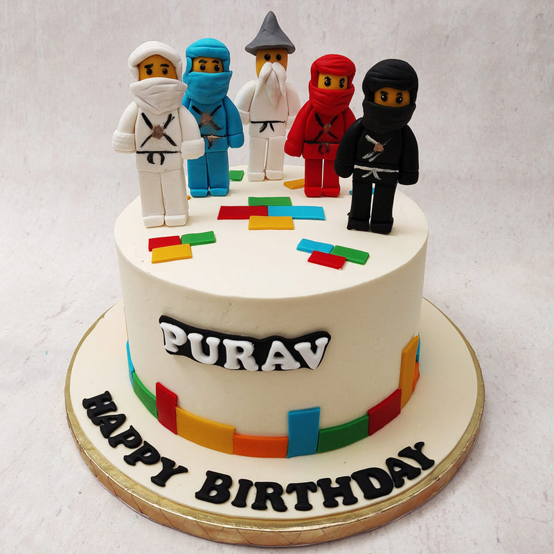 Inspired by the animated series by The Lego Group that chronicles the fictional world of Ninjago, this Ninjago birthday cake for kids features a white base with realistic figurines of all 6 ninjas on top.