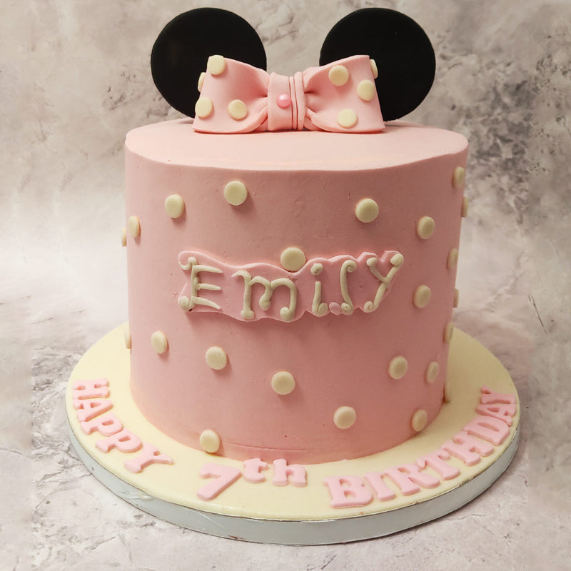 Adorning the pastel pink canvas of this Minnie Ears Cake are white chocolate polka dots, each meticulously placed to represent Minnie’s timeless fashion sense.