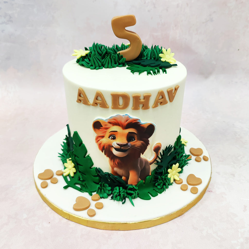 The base of this Little Simba Cake is surrounded by lush green leaves and flowers, symbolising the rich savannah where Simba’s adventures unfold. 