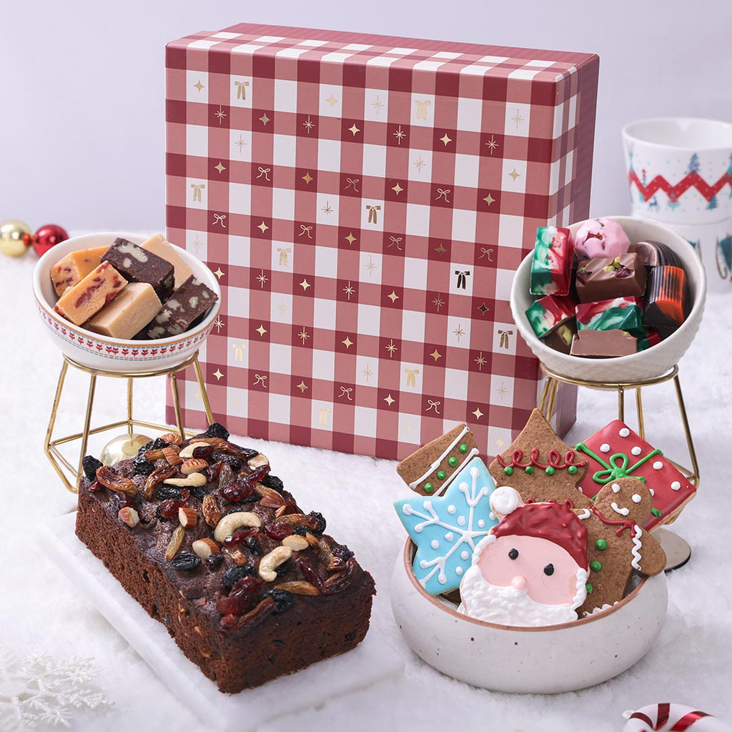 Luxury Christmas Hamper box featuring a rich plum cake, assorted festive cookies, fudge, and artisan chocolates in a high-end presentation.
