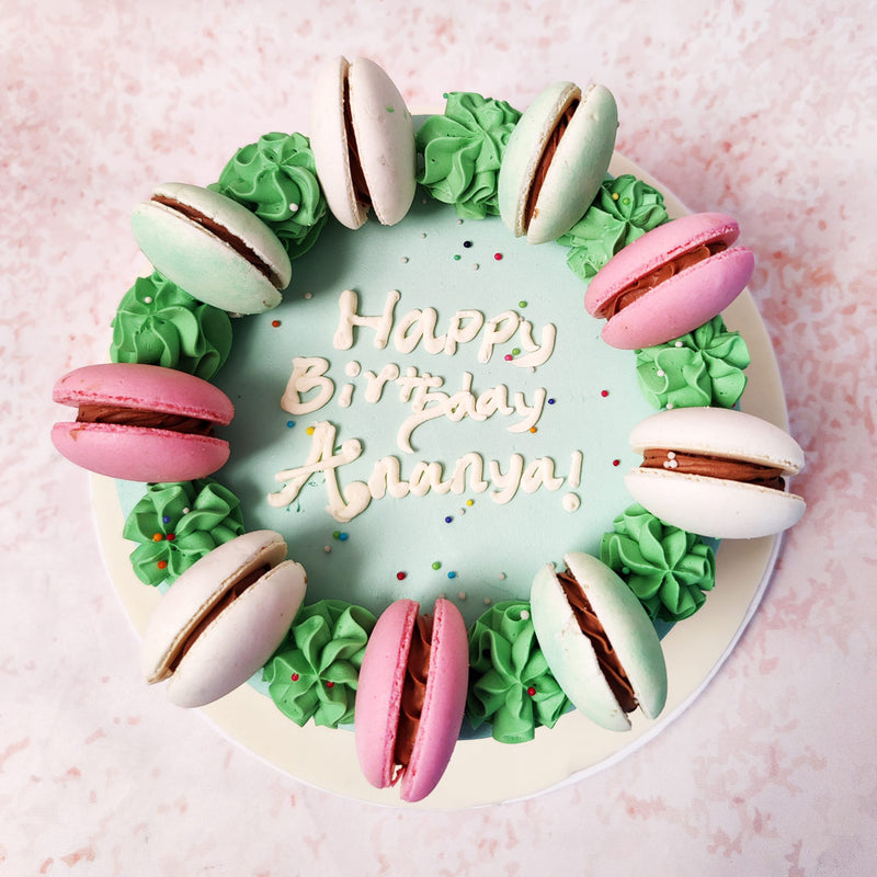  The soft swirls of green buttercream on this  Colourful Macaron Cake create a contrast in texture, adding depth and an organic feel to the overall aesthetic.