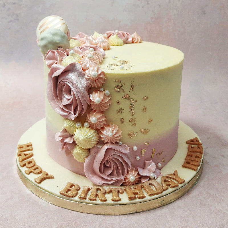 With a cream to pastel pink ombre as the colour palette for the base and edible, buttercream roses cascading down the sides, this macaron cake design would be perfect as a birthday cake for wife