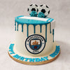 This football theme cake features a clean white base, topped with a blue drip pattern in honour of the football club's colours.