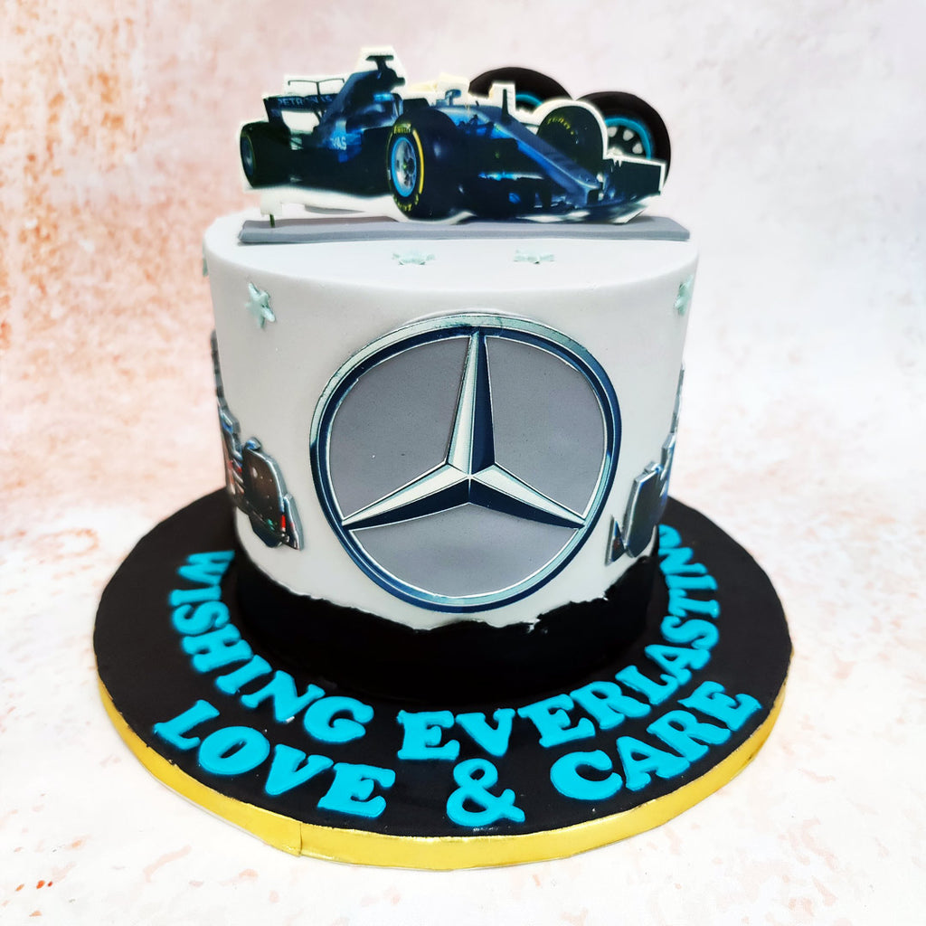 This Mercedes Benz Cake features a detailed edible model of a sleek Mercedes Benz car perched atop, exuding luxury and elegance. 