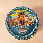 At the centre of this Mighty Pups Birthday Cake, proudly displayed, is an edible poster featuring the beloved Paw Patrol gang, their iconic logo shining brightly beside them.