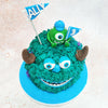 Atop this Mike and Sully Cake sits the ever-watchful Mike, the one-eyed green monster, holding festive flags that celebrate the occasion with his characteristic enthusiasm.