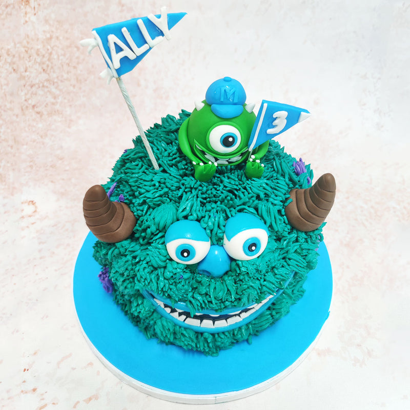 Atop this Mike and Sully Cake sits the ever-watchful Mike, the one-eyed green monster, holding festive flags that celebrate the occasion with his characteristic enthusiasm.