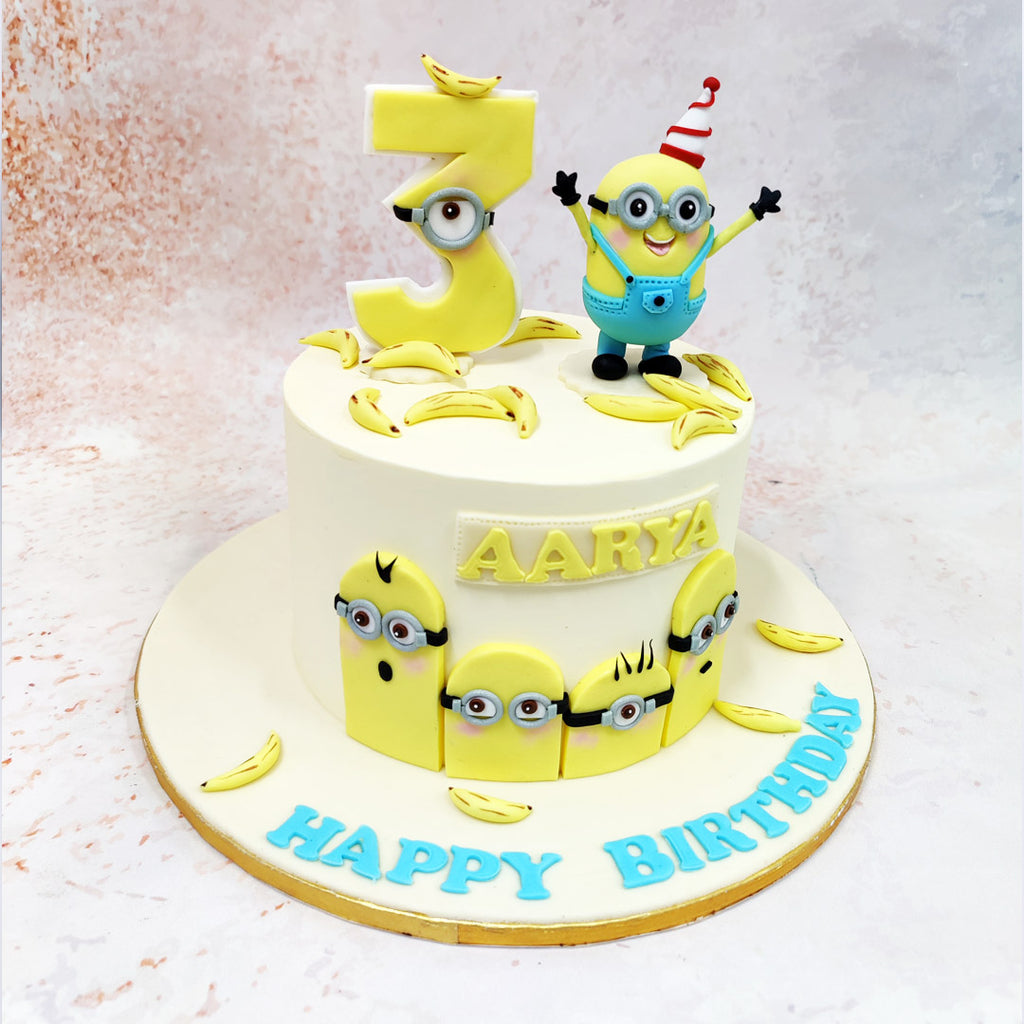 Designed with a bold yellow base and bright blue accents, this Minions Banana Cake features the cheeky faces of Minions peeking out from the sides, each one hand-crafted to capture their quirky expressions. 