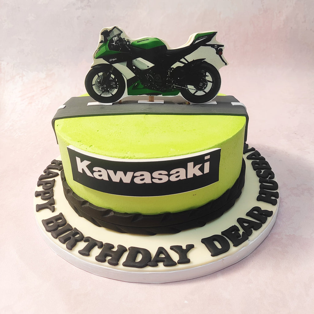 At the bottom, a tire motif adds a touch of rugged flair draped around the circumference, while atop the Biker Cake design, a meticulously crafted road track invites you to embark on a sweet journey. 