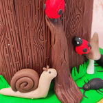 A two tiered nature cake essentially, this design features a bottom tier that's entirely replicative of a tree stump. 
