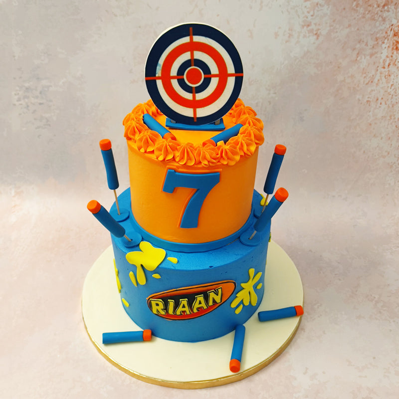 This two tier Nerf cake is crafted in an artistic yet simplistic manner that replicates the playground where children would run around playing paintball or playing with toys. 