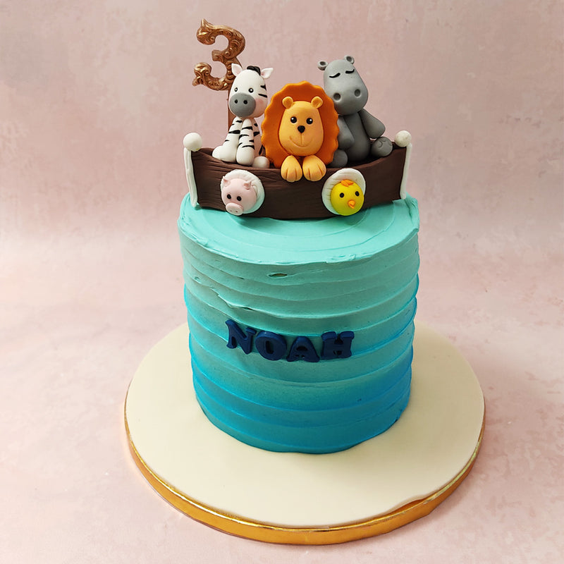  With a dark to light blue buttercream ombre coating the base of this Noah's cake design