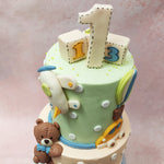 This teddy bear theme cake  is embellished with delicate white polka dots, creating a whimsical pattern that adds a touch of charm to the overall design. 