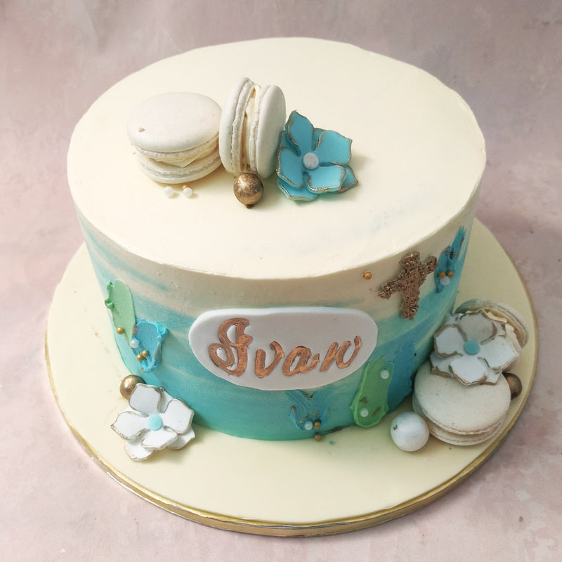 The ombre blue and white layers of this ombre christening cake represent purity and new beginnings, while the macarons add a touch of elegance and sweetness. 
