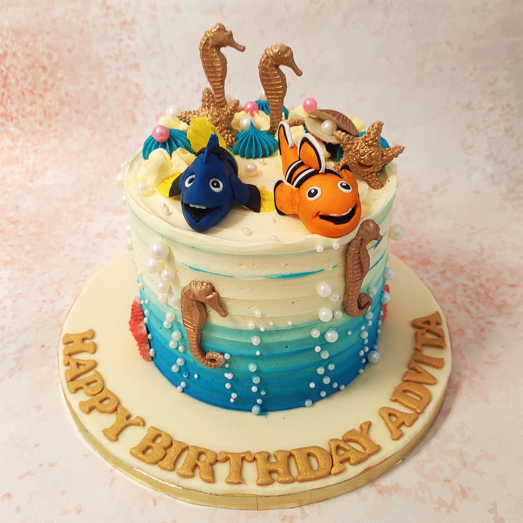 Flanking these colourful fish are charming 3D golden seahorses, adding a touch of elegance and fantasy to this CartoonTheme Cake.