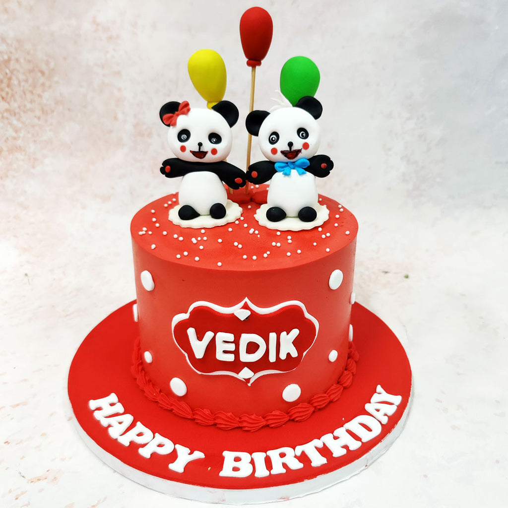 The stars of this Panda Couple Cake are two lovingly crafted panda figurines, each with its own distinctive personality - one sporting a sweet red bow and the other wearing a dapper blue bowtie. 